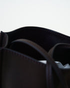 Closeup view of black leather bag on white background, with no model shown.