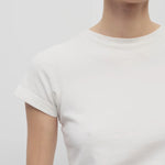Front closeup view of white tori top on model against a white background.