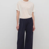 Front view of dark navy ukira pant on model wearing white t-shirt, against a white background.