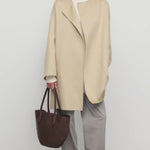 Front view of light pebble verlain coat on model wearing grey pants, against a white background.