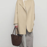 Front view of light pebble verlain coat on model wearing grey pants, against a white background.