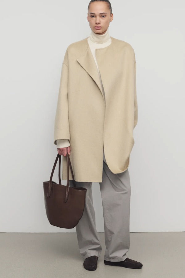 Front view of light pebble verlain coat on model wearing grey pants, against a white background.