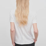 Back view of white welser t-shirt on model wearing black trousers, against a white background.