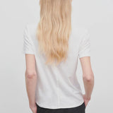 Back view of white welser t-shirt on model wearing black trousers, against a white background.