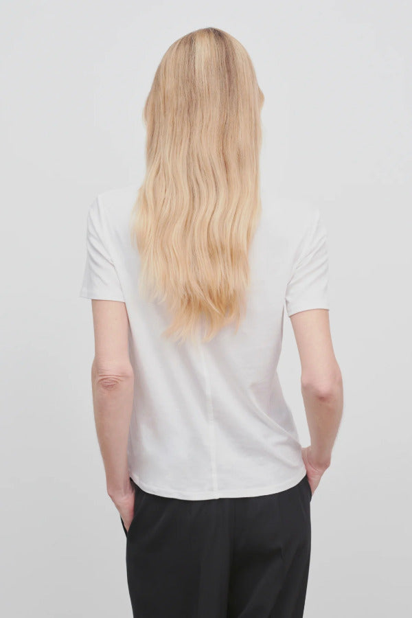 Back view of white welser t-shirt on model wearing black trousers, against a white background.