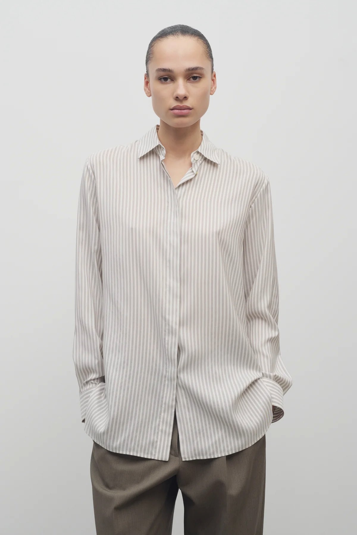 Front view of Long sleeve silk shirt in white with grey on brunette haired model  worn with khaki trousers.