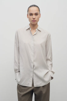Front view of Long sleeve silk shirt in white with grey on brunette haired model  worn with khaki trousers.