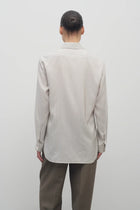 Back view of Long sleeve silk shirt in white with grey on brunette haired model  worn with khaki trousers.
