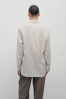 Back view of Long sleeve silk shirt in white with grey on brunette haired model  worn with khaki trousers.
