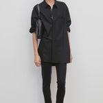 Front view of black woolworth pant on model wearing black tunic top and black sandals against a white background.