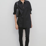 Front view of black woolworth pant on model wearing black tunic top and black sandals against a white background.