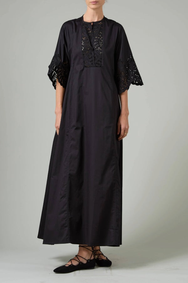 Front view of black rachel long dress on model wearing black flats, against a white background.