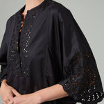 Side closeup view of black rachel long dress on model, against a white background.