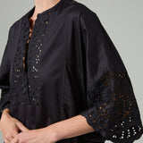 Side closeup view of black rachel long dress on model, against a white background.