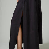 Alternate side closeup view of black rachel long dress on model wearing black flats, against a white background.