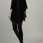 Back view of black rachel mini dress on model wearing black flats, against a white background.