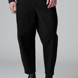 Front view of black japanese tobi trousers on model wearing black top and boots, against a grey background.