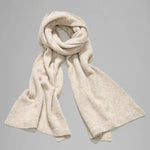 Rolled view of camel knitted scarf on grey background, with no model shown.