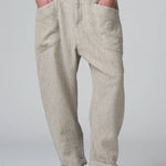 Front view of chalk low crotch comfort fit trouser on model wearing white t-shirt, against a grey background.