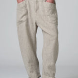 Front view of chalk low crotch comfort fit trouser on model wearing white t-shirt, against a grey background.
