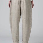 Back view of chalk low crotch comfort fit trouser on model wearing white t-shirt, against a grey background.