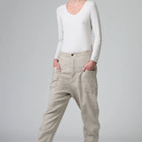 Front view of chalk low crotch comfort fit trouser on model wearing white t-shirt, against a grey background.