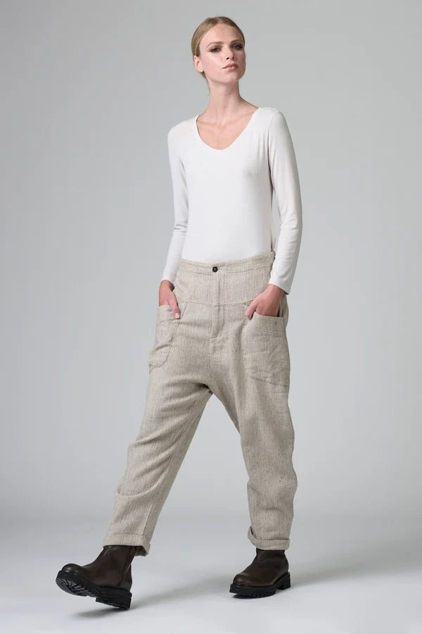 Front view of chalk low crotch comfort fit trouser on model wearing white t-shirt, against a grey background.