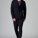 Front view of blue wool regular jacket on model wearing blue shirt and pants with boots, against a grey background.