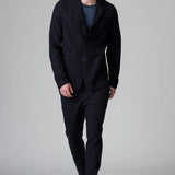 Front view of blue wool regular jacket on model wearing blue shirt and pants with boots, against a grey background.