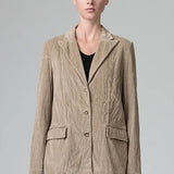 Front view of camel regular fit jacket on  model wearing camel pants and black top, against a grey background.