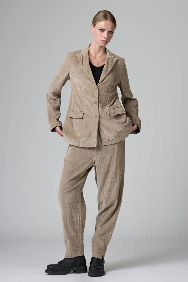 Front view of camel regular fit jacket on model wearing camel pants and black top with boots, against a grey background.