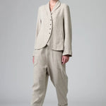 Front view of chalk herringbone jacket on model wearing chalk pants, against a grey background.