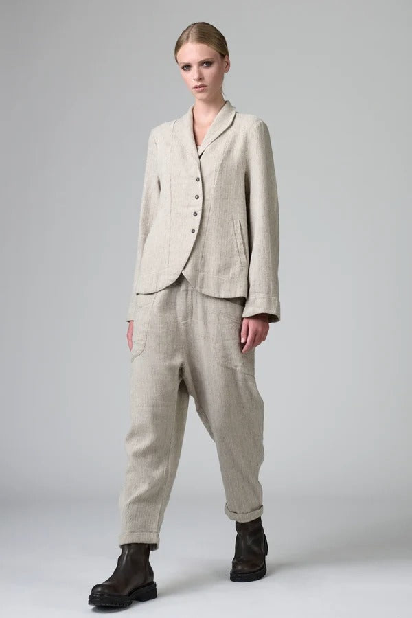 Front view of chalk herringbone jacket on model wearing chalk pants, against a grey background.
