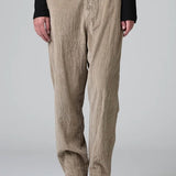 Front view of camel regular fit trousers on model wearing black top and boots, against a grey background.