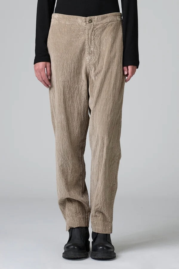 Front view of camel regular fit trousers on model wearing black top and boots, against a grey background.