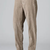 Side view of camel regular fit trousers on model wearing black top and boots, against a grey background.