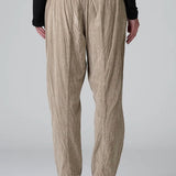 Back view of Camel Regular fit trousers on model wearing black top and boots, against a grey background.