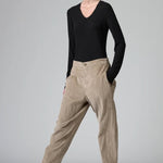 Front view of camel regular fit trousers on model wearing black top and boots, against a grey background.