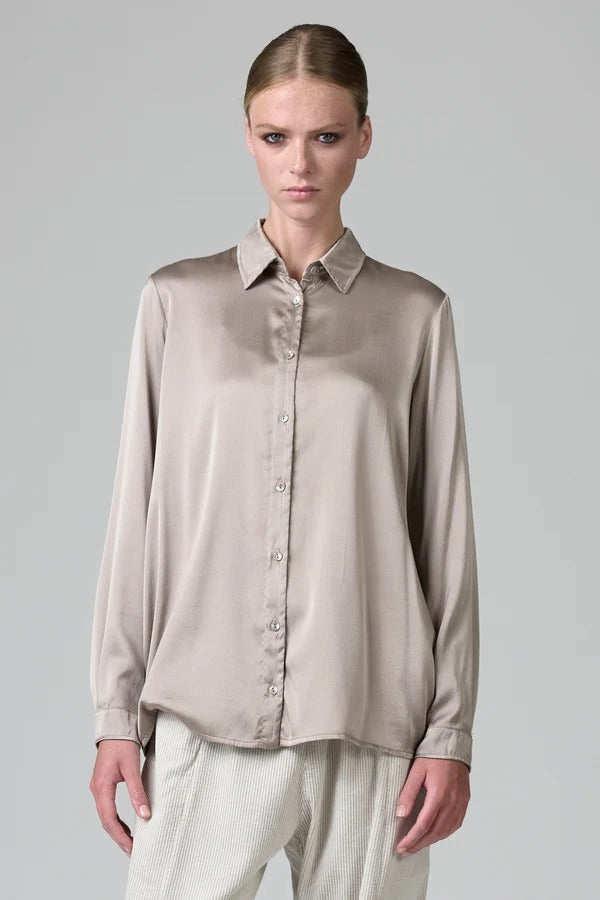 Front view of stone silk satin regular fit shirt on model wearing chalk pants, against a grey background.