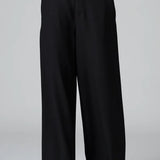 Front view of black stretch wide leg trousers on model wearing black top and boots, against a grey background.