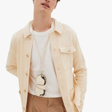 Back view of white valextra glasses case with lanyard on model wearing white t-shirt with orange trousers, against a white background.