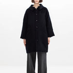 Front view of black bonnet drivers down coat on model wearing grey pants, against a white background.