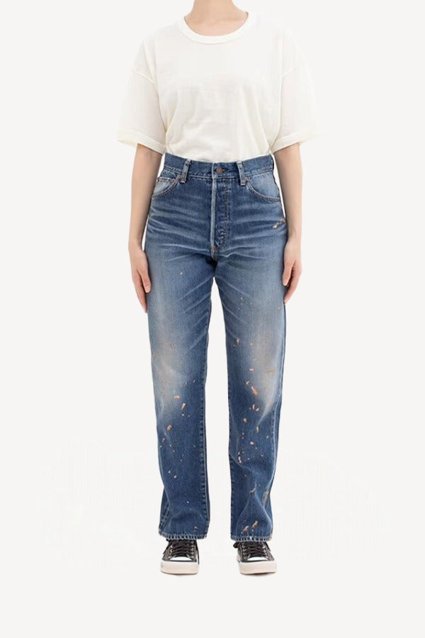 Front view of damaged social sculpture w18 jean on model wearing white t-shirt and sneakers, against a white background.