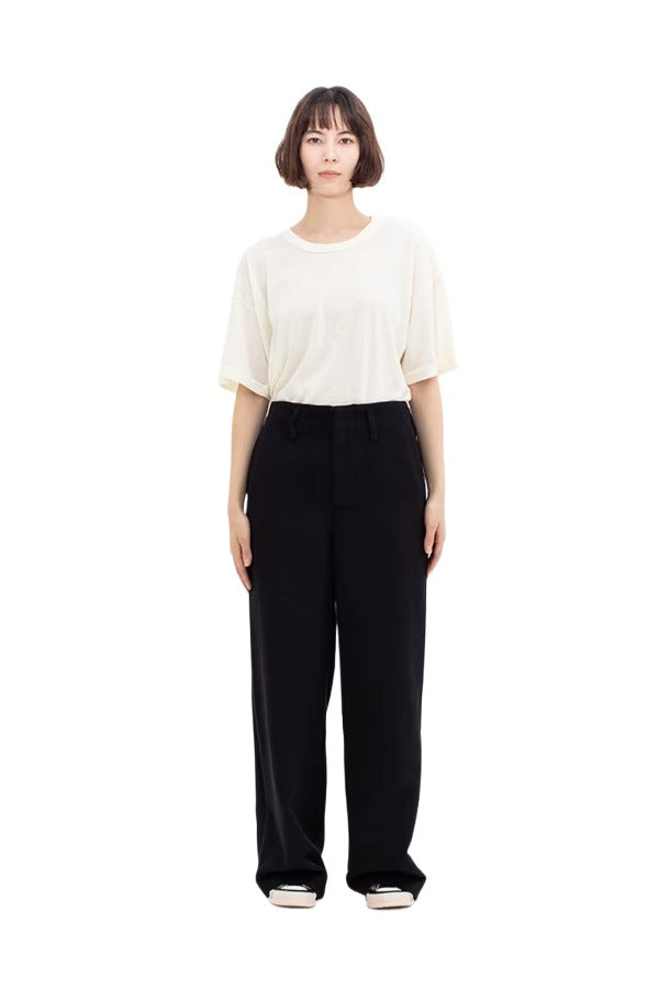 Front view of black wide silk pants on model wearing white t-shirt and sneakers, against a white background.